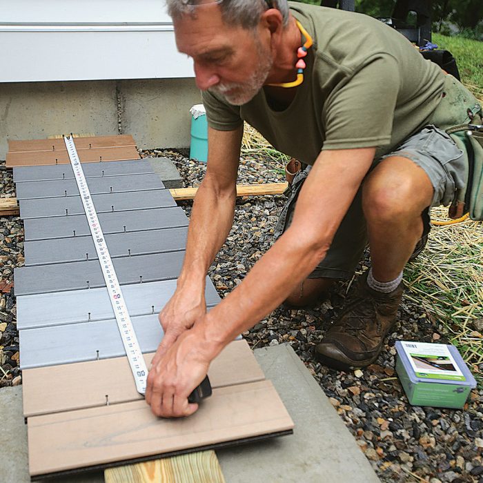 Man measuring and comparing different types of deck boards.