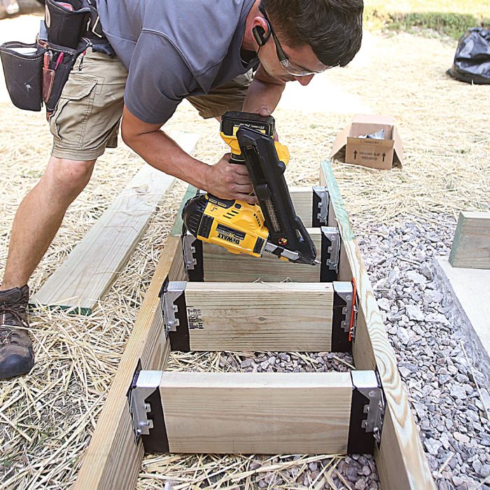 Man adds joist hangers to stair boxes.