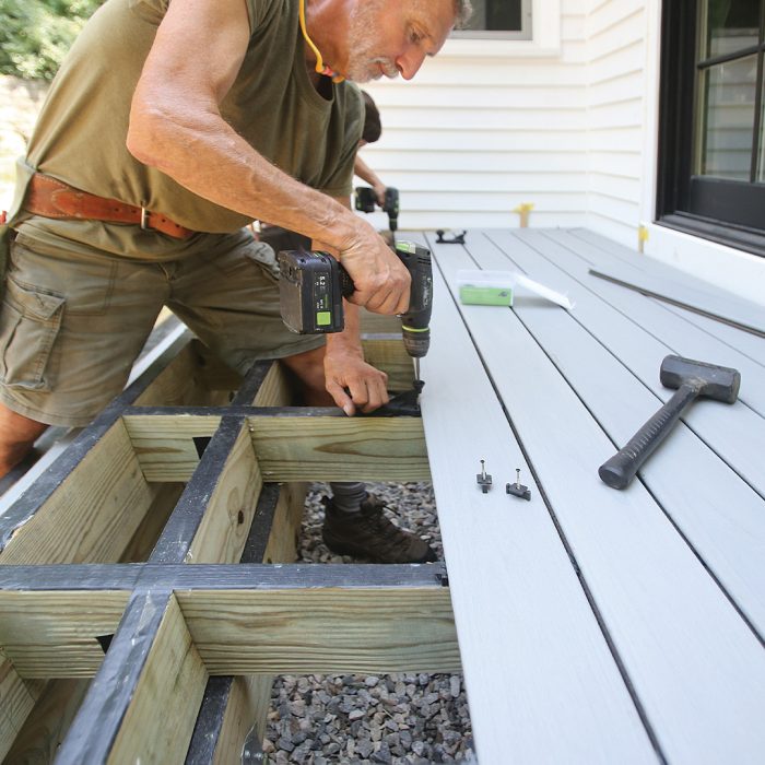 Man drills fasteners into the deck's inside tread boards.