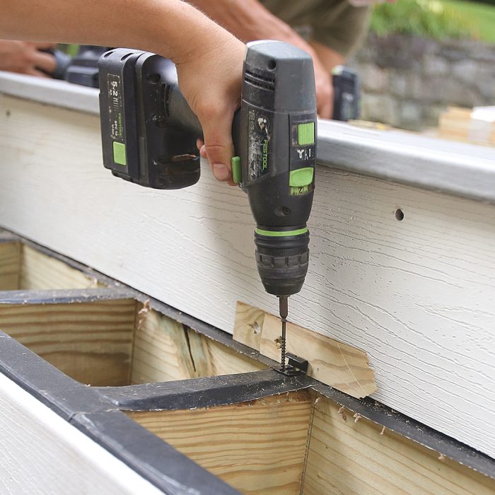 Man drills fasteners into the tread boards.