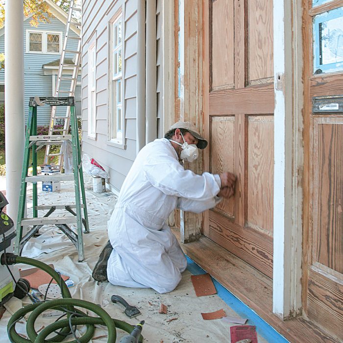 Photo of a man collecting lead-paint chips safely.