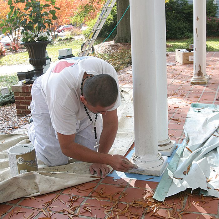 Man applying primer to ensure the topcoat has a uniform sheen and stains are fully hidden.